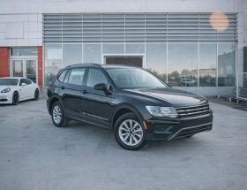 Svart SUV parkerad framför en bilhall för nätauktion.