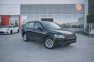 Svart SUV parkerad framför en bilhall för nätauktion.