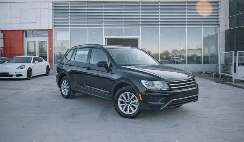 Svart SUV parkerad framför en bilhall för nätauktion.